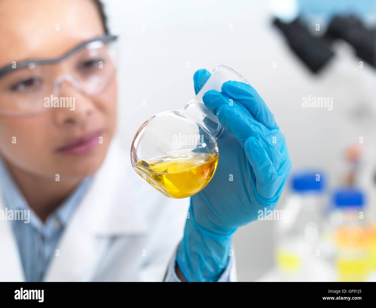 PROPERTY RELEASED. MODEL RELEASED. Scientist preparing a chemical formula in a glass flask in a laboratory. Stock Photo