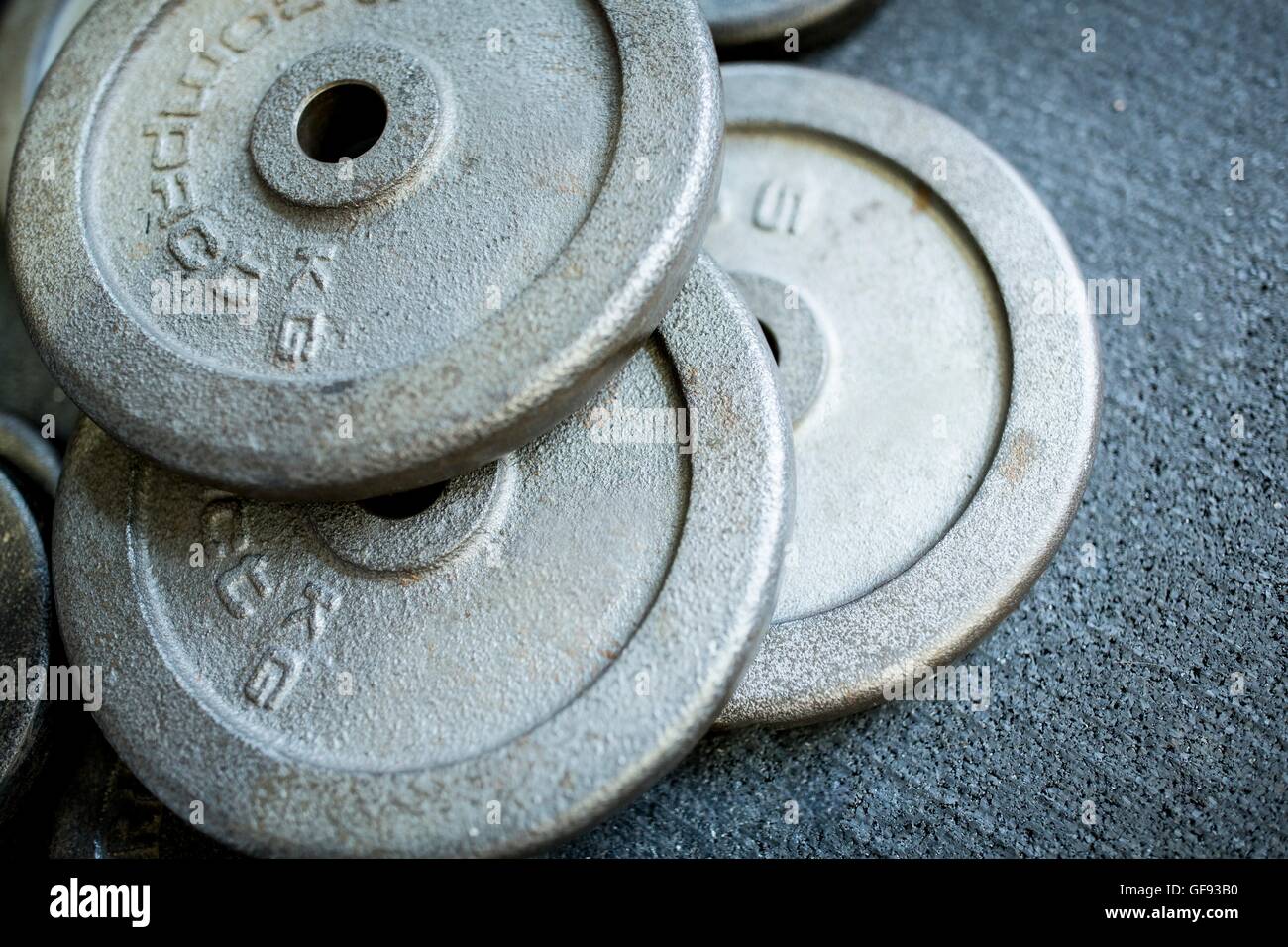 PROPERTY RELEASED. Close-up of heavy weight plates kept by strack on ground. Stock Photo