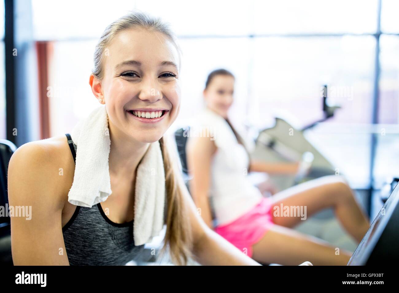 PROPERTY RELEASED. MODEL RELEASED. Portrait of young woman with napkin around her neck in gym, smiling. Stock Photo