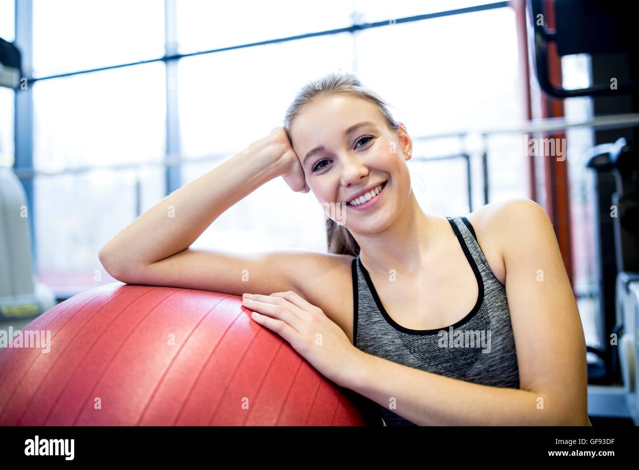 PROPERTY RELEASED. MODEL RELEASED. Portrait of young woman with fitness ball in gym. Stock Photo