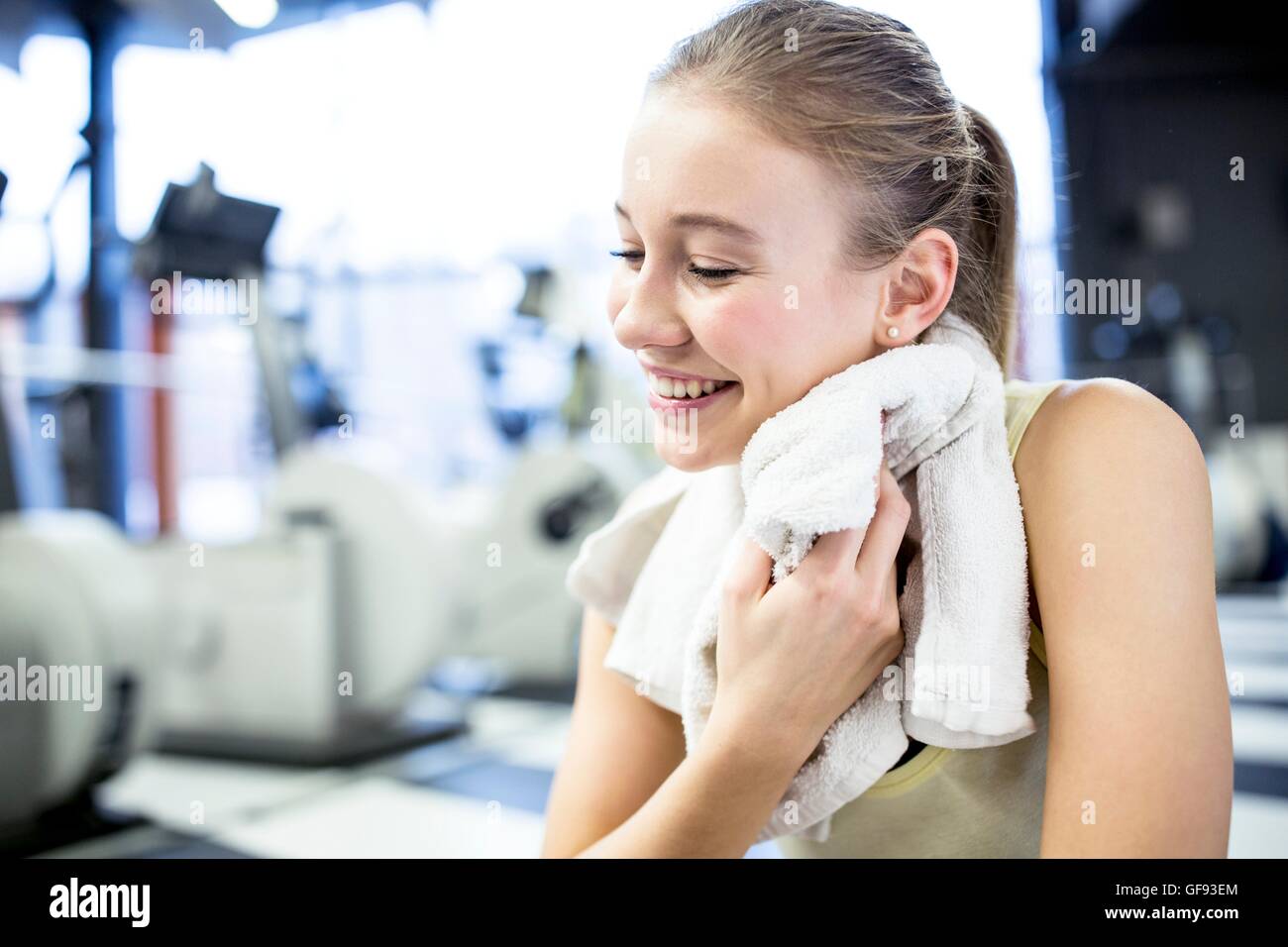 PROPERTY RELEASED. MODEL RELEASED. Young woman wiping her sweat with towel after exercising in gym. Stock Photo