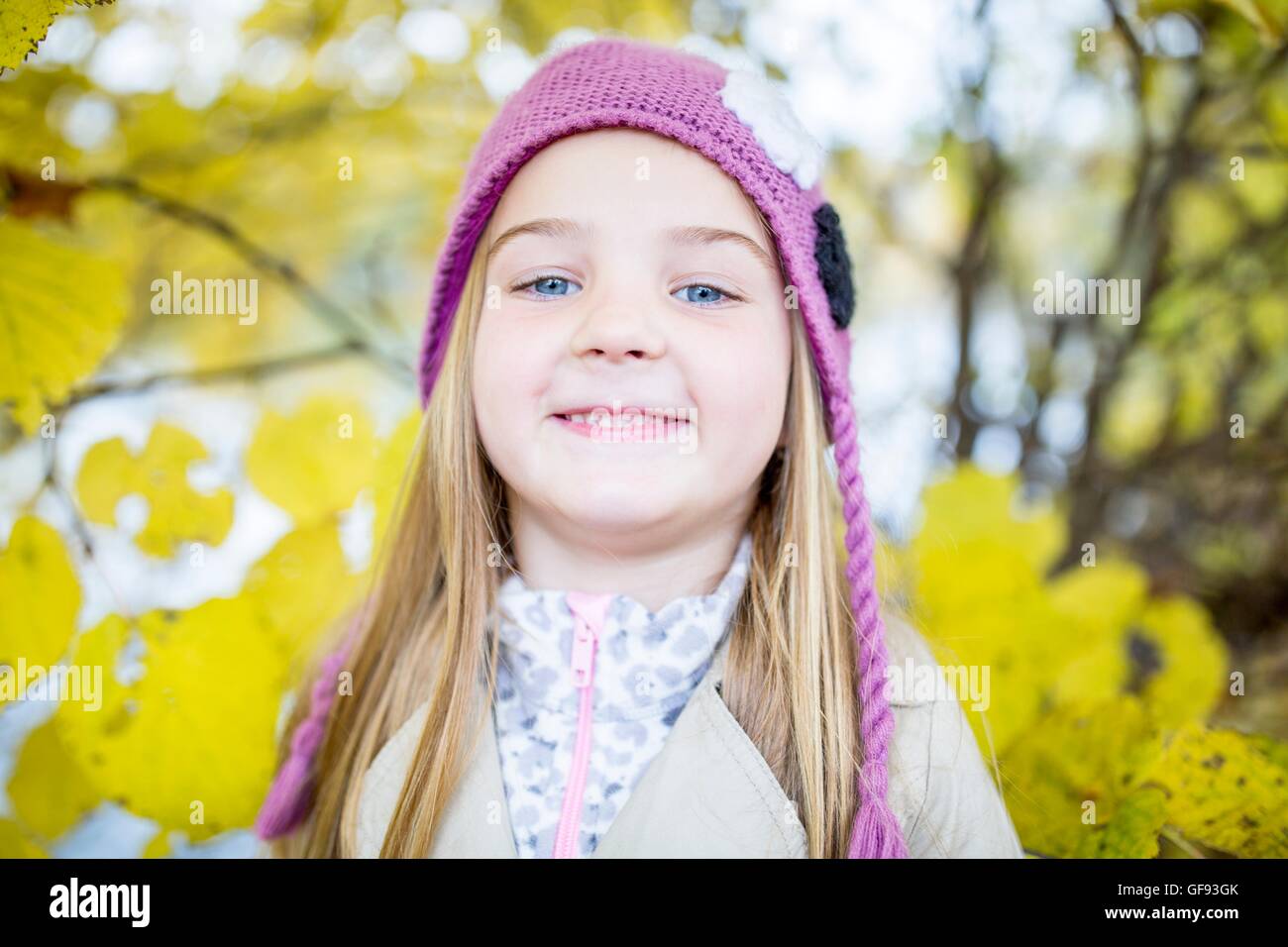 MODEL RELEASED. Blonde girl wearing woolly hat and smiling, close-up, portrait. Stock Photo