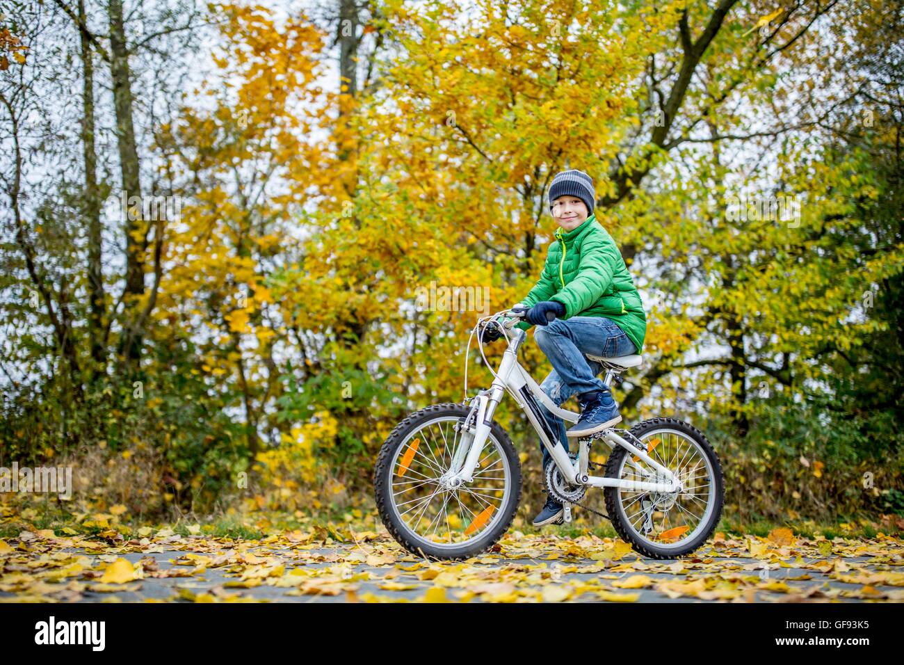 MODEL RELEASED. Portrait of boy cycling in autumn. Stock Photo
