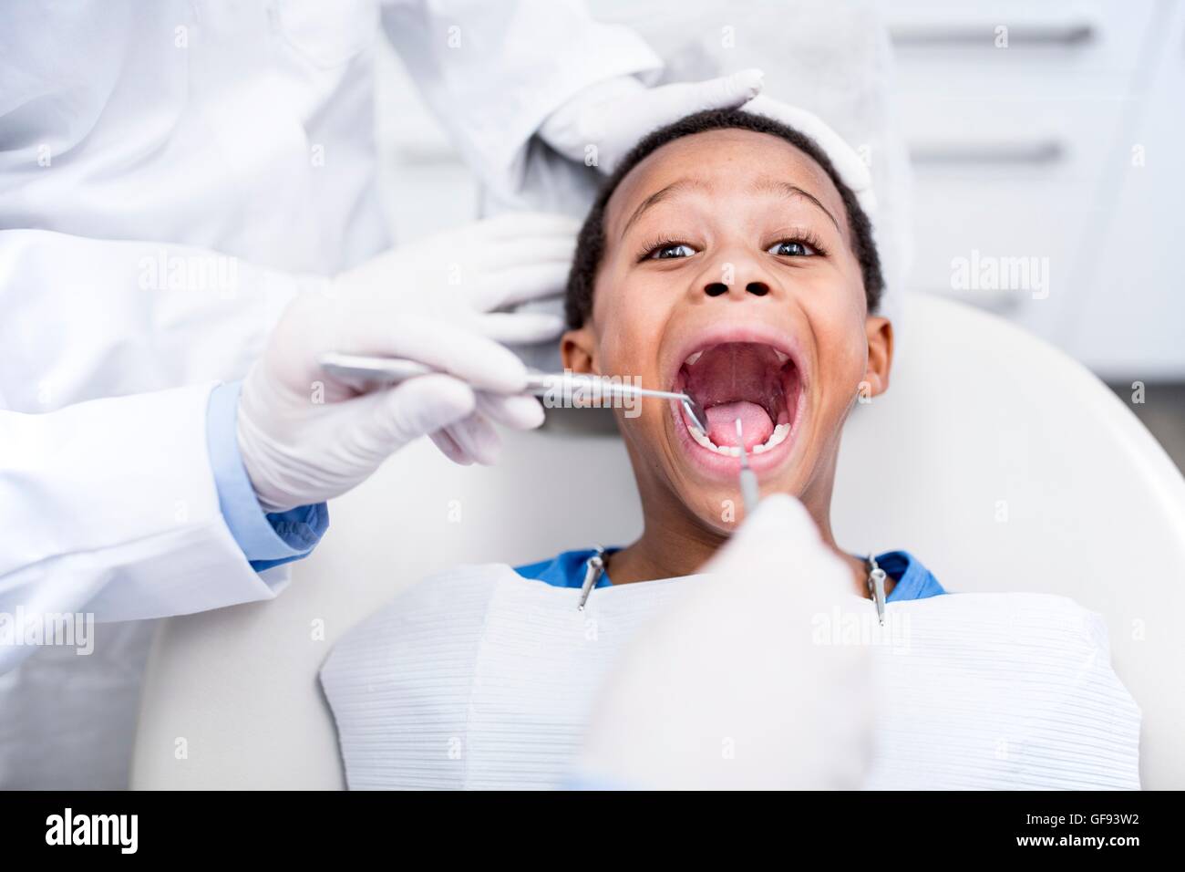 MODEL RELEASED. Doctor examining boy's teeth in clinic. Stock Photo