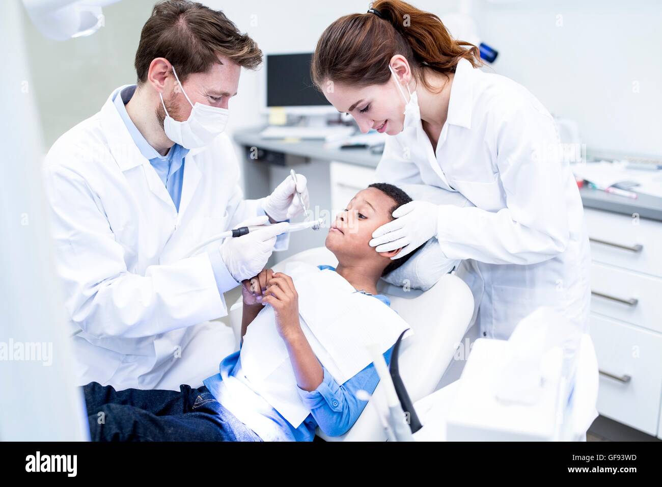 MODEL RELEASED. Scared boy looking at dental drill in dentist's hand. Stock Photo