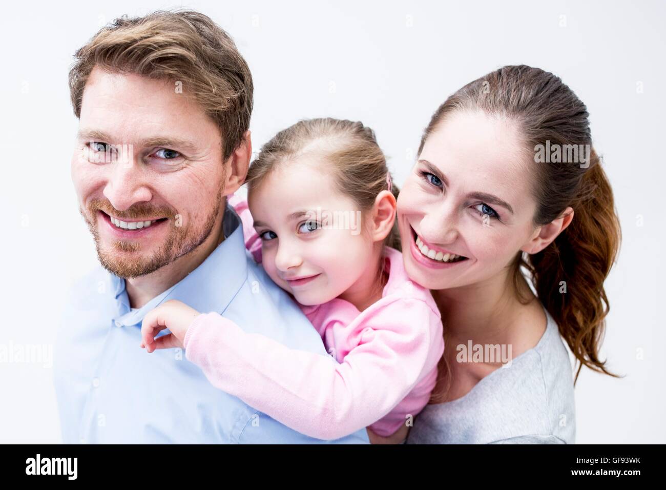 MODEL RELEASED. Portrait of dentist and dental assistant playing with girl, smiling. Stock Photo