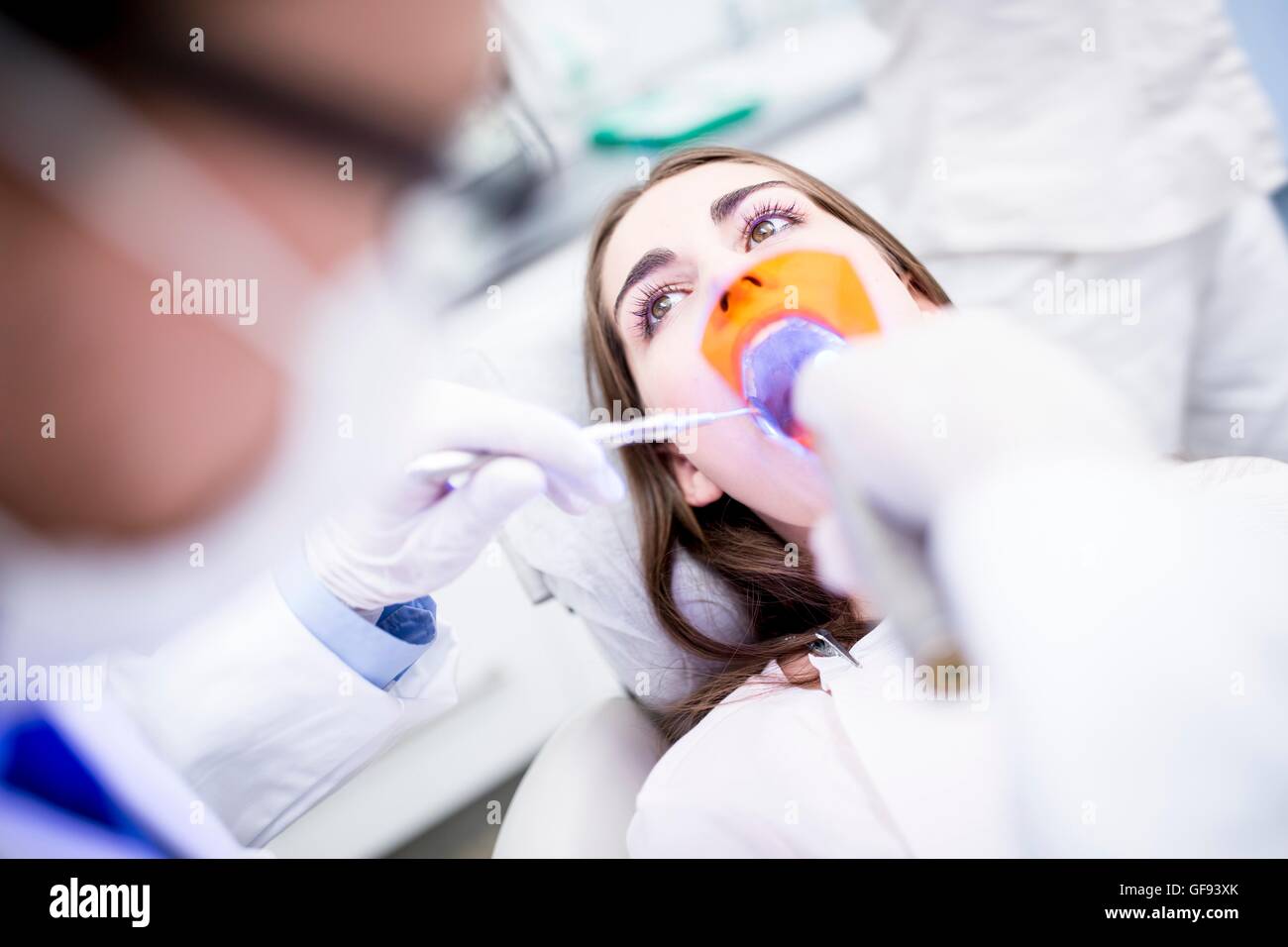 MODEL RELEASED. Patient receiving ultraviolet light procedure at dentist clinic. Stock Photo