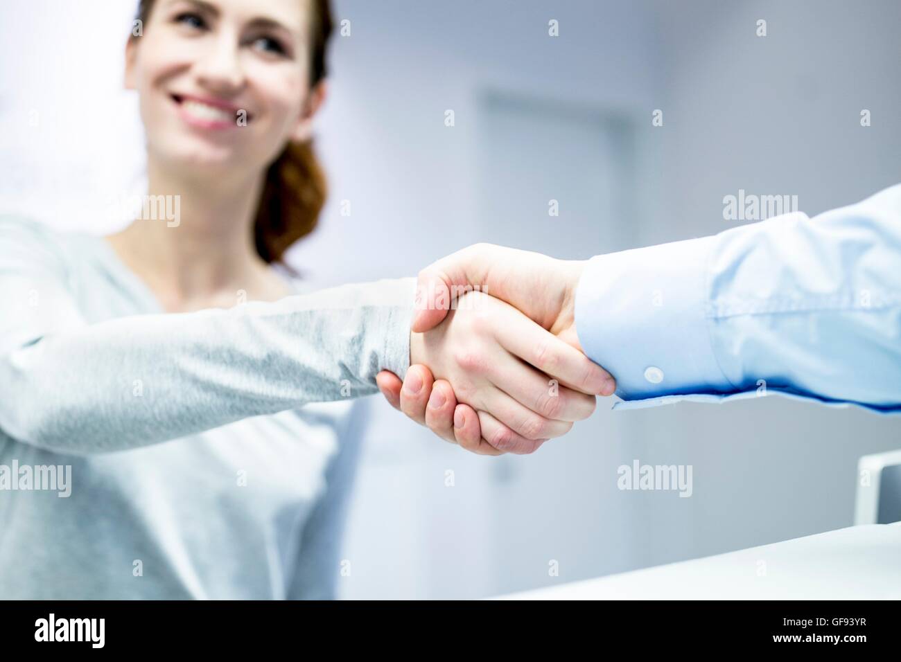 MODEL RELEASED. Dentist shaking hands with patient in clinic. Stock Photo