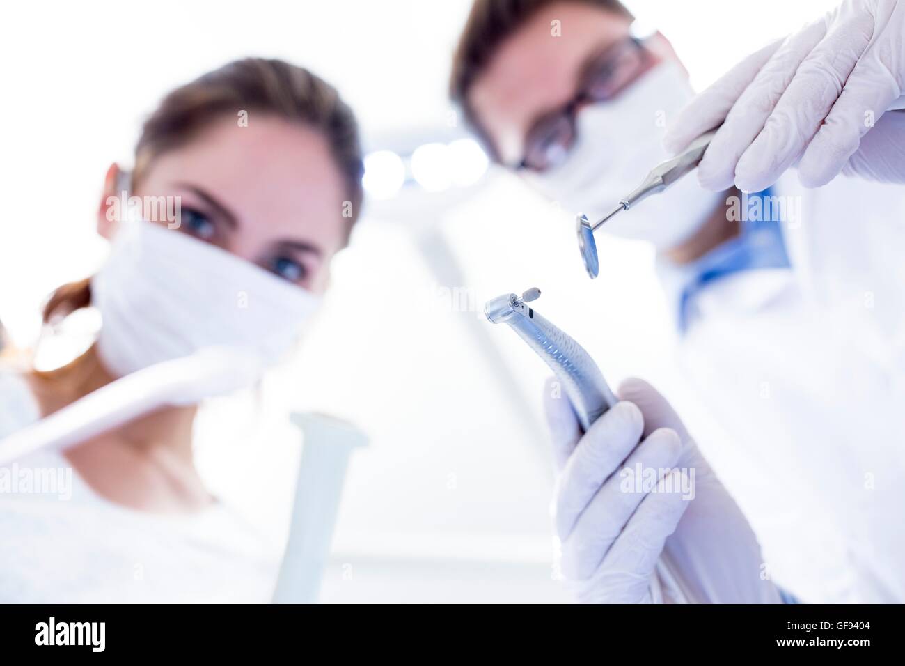 MODEL RELEASED. Dentist and dental assistant conducting dental operation. Stock Photo