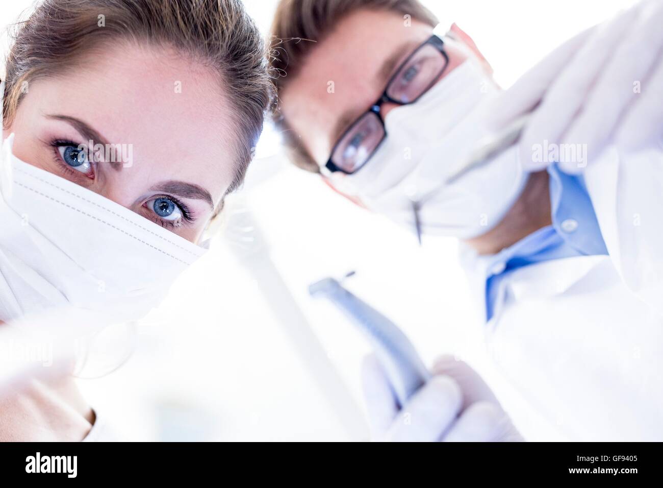 MODEL RELEASED. Dentist and dental assistant conducting dental operation. Stock Photo