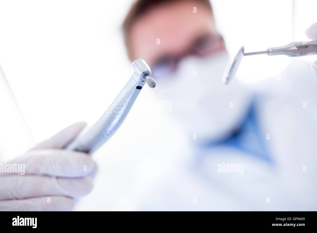 MODEL RELEASED. Dentist holding dental drill and angled mirror Stock ...