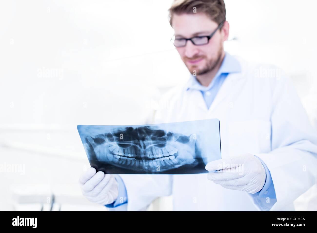 MODEL RELEASED. Dentist and dental assistant looking at x-ray image. Stock Photo