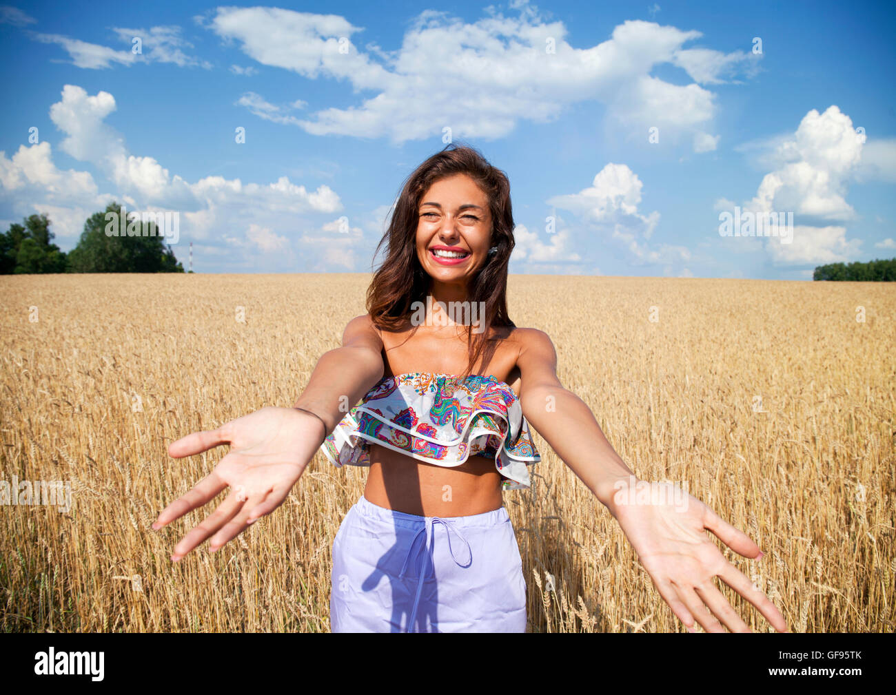 Beautiful young woman in a wheat golden field Stock Photo - Alamy
