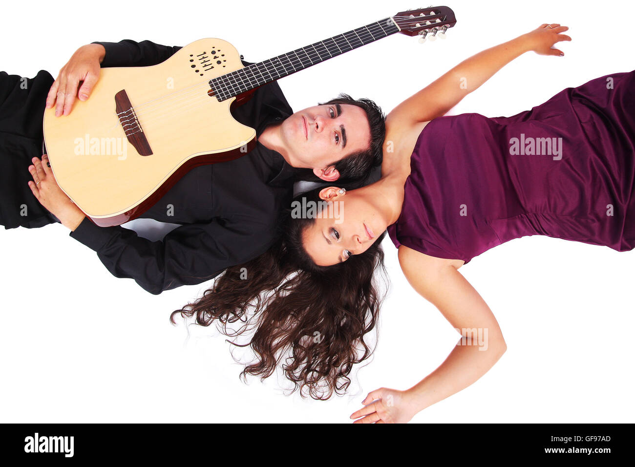 A female singer and a male guitarrist laying down in white background Stock Photo