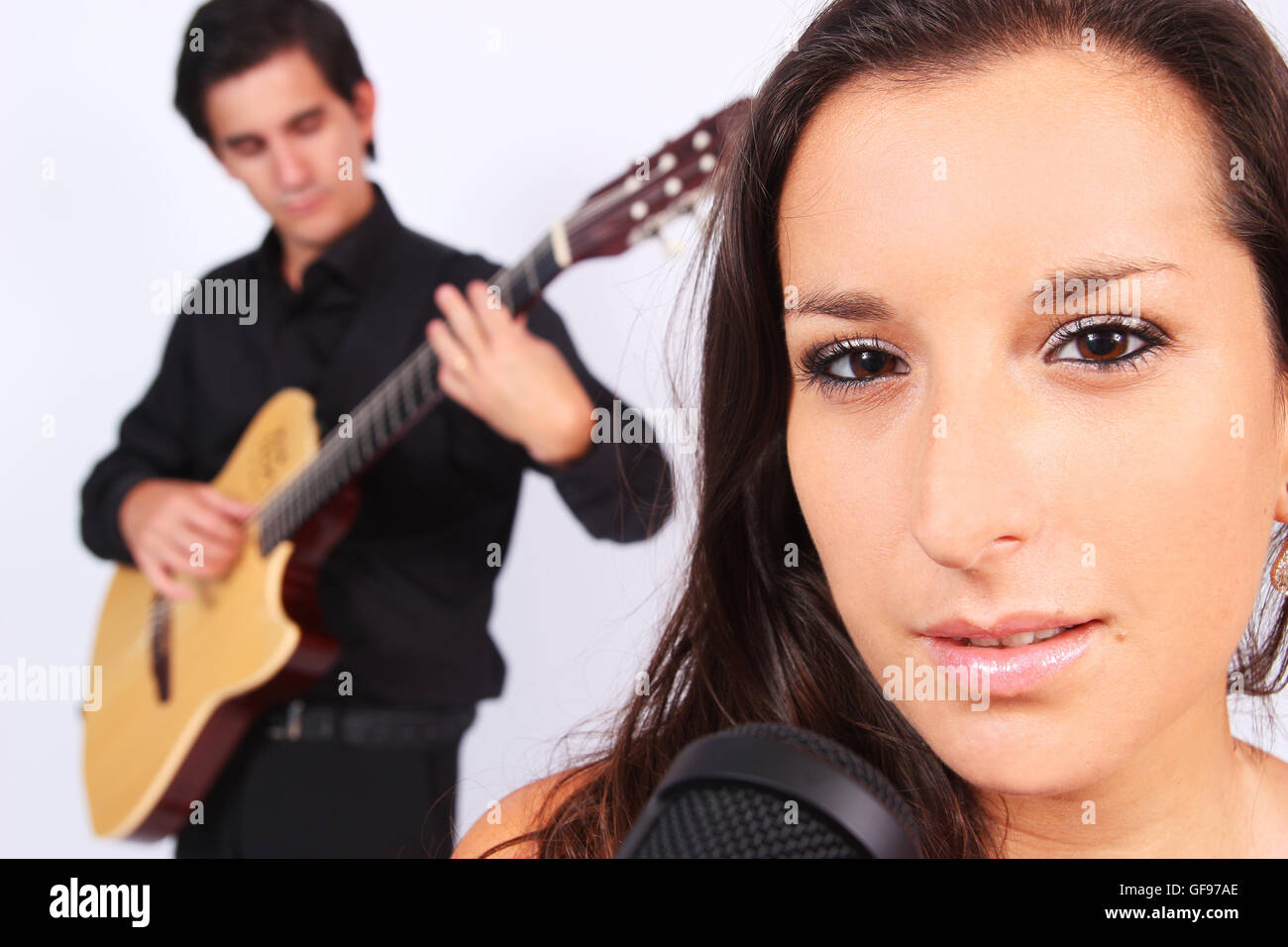 A female singer and a male guitarrist in action in white background Stock Photo