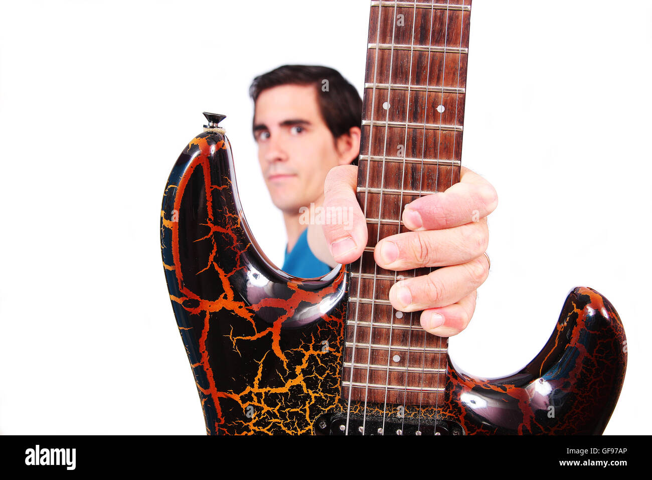 A male guitarrist in action holding his electric guitar in white background Stock Photo