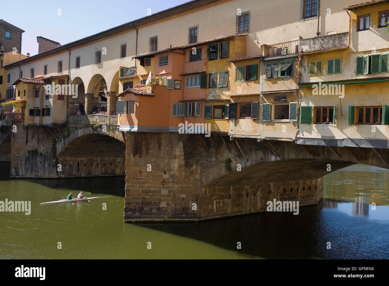 Close-up of the Ponte Vecchio spanning the River Arno in Florence Tuscany, Italy, with a double scull shooting the bridge Stock Photo
