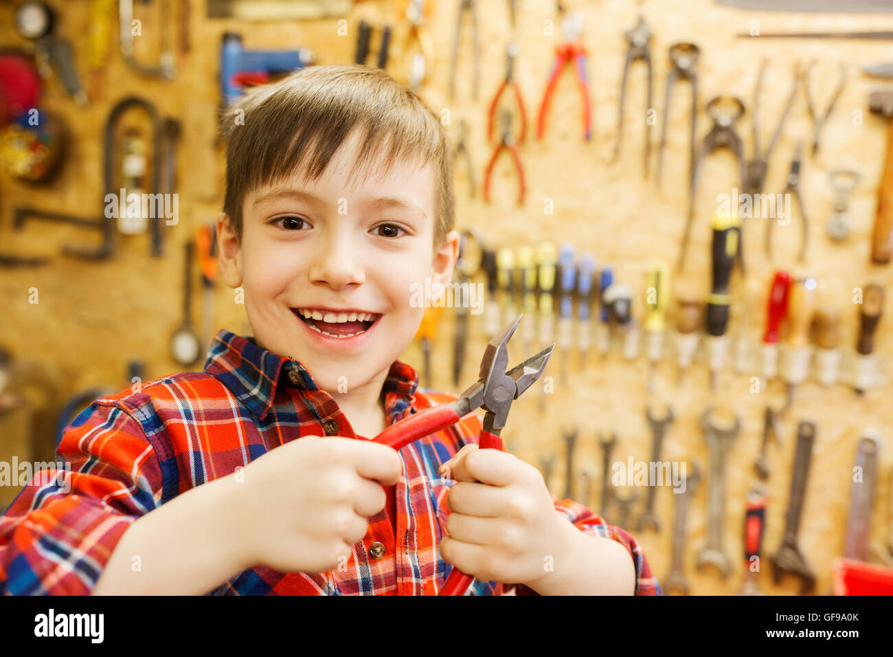 happy little boy with pliers at workshop Stock Photo