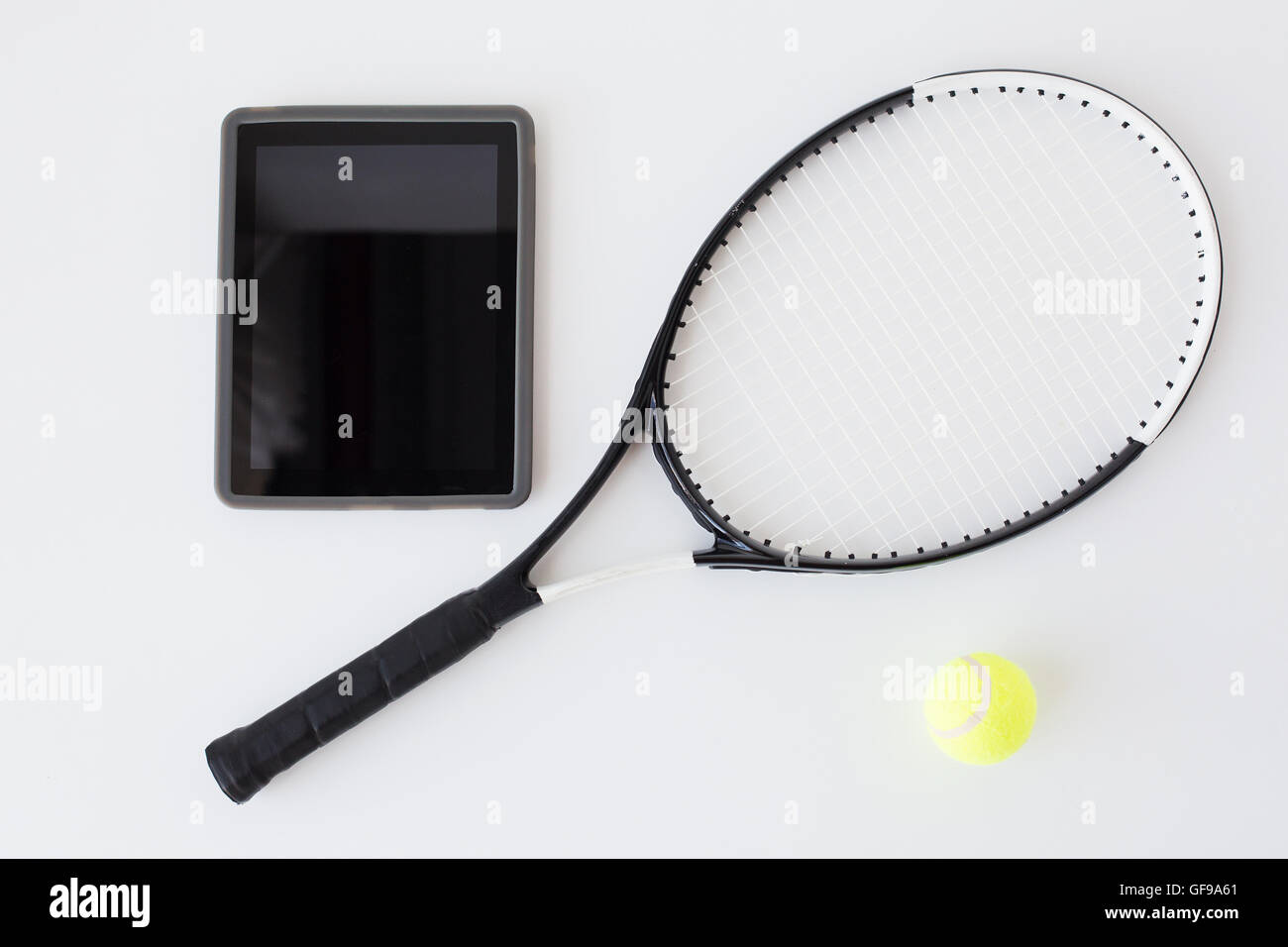 close up of tennis racket with ball and tablet pc Stock Photo