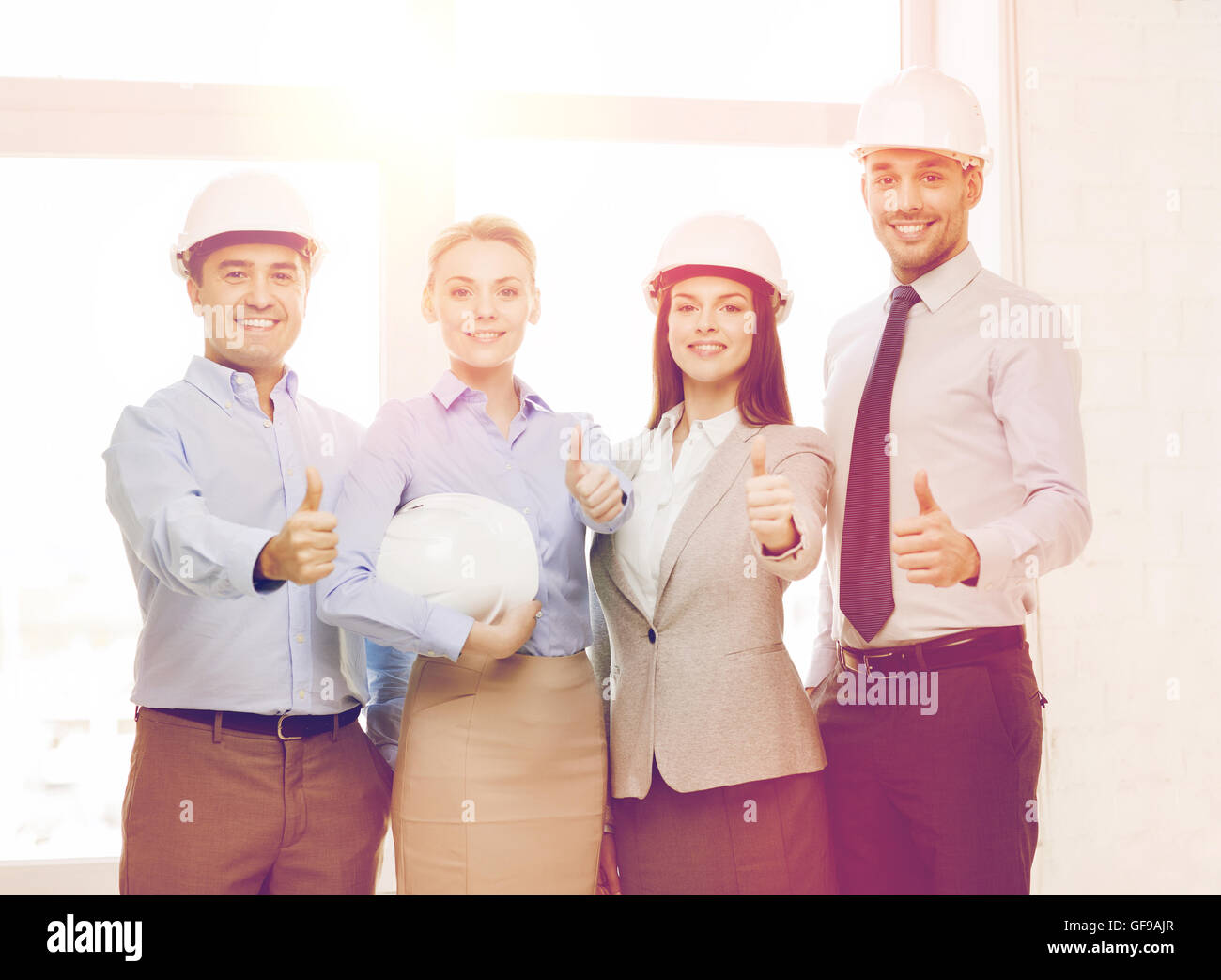 happy business team in office showing thumbs up Stock Photo - Alamy