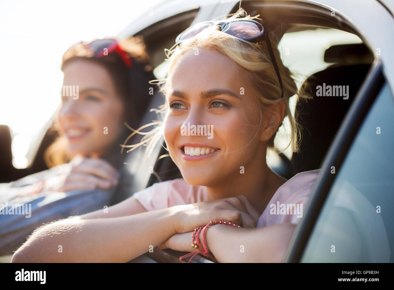 happy teenage girls or women in car at seaside Stock Photo - Alamy