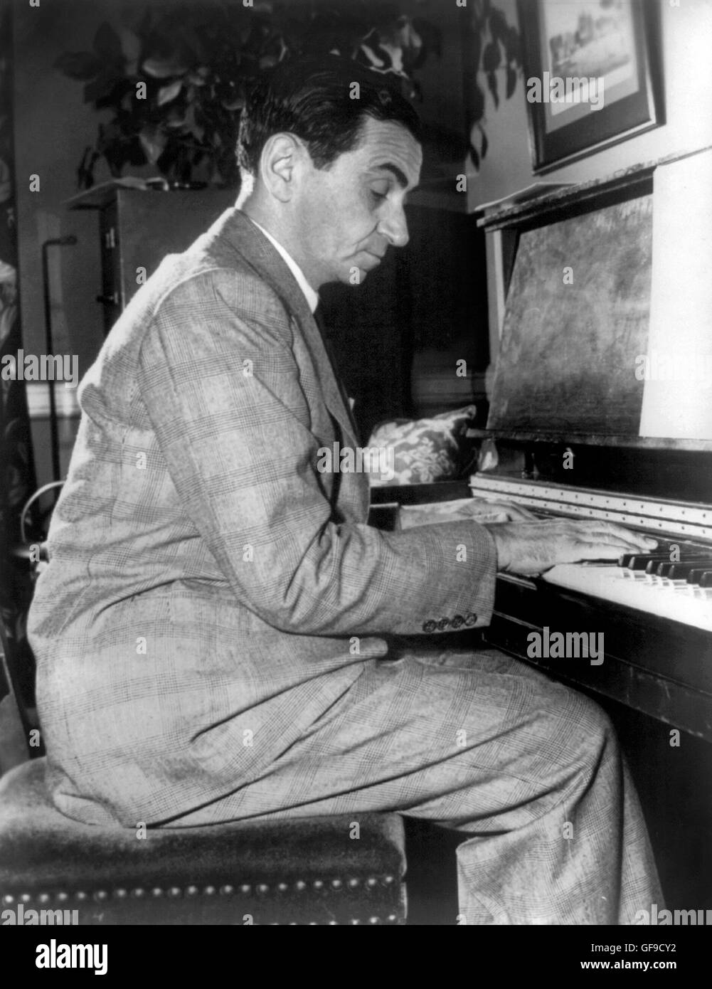 Irving Berlin playing the piano. Portrait of the American composer and lyricist, Irving Berlin (1888-1989) c.1948. Stock Photo