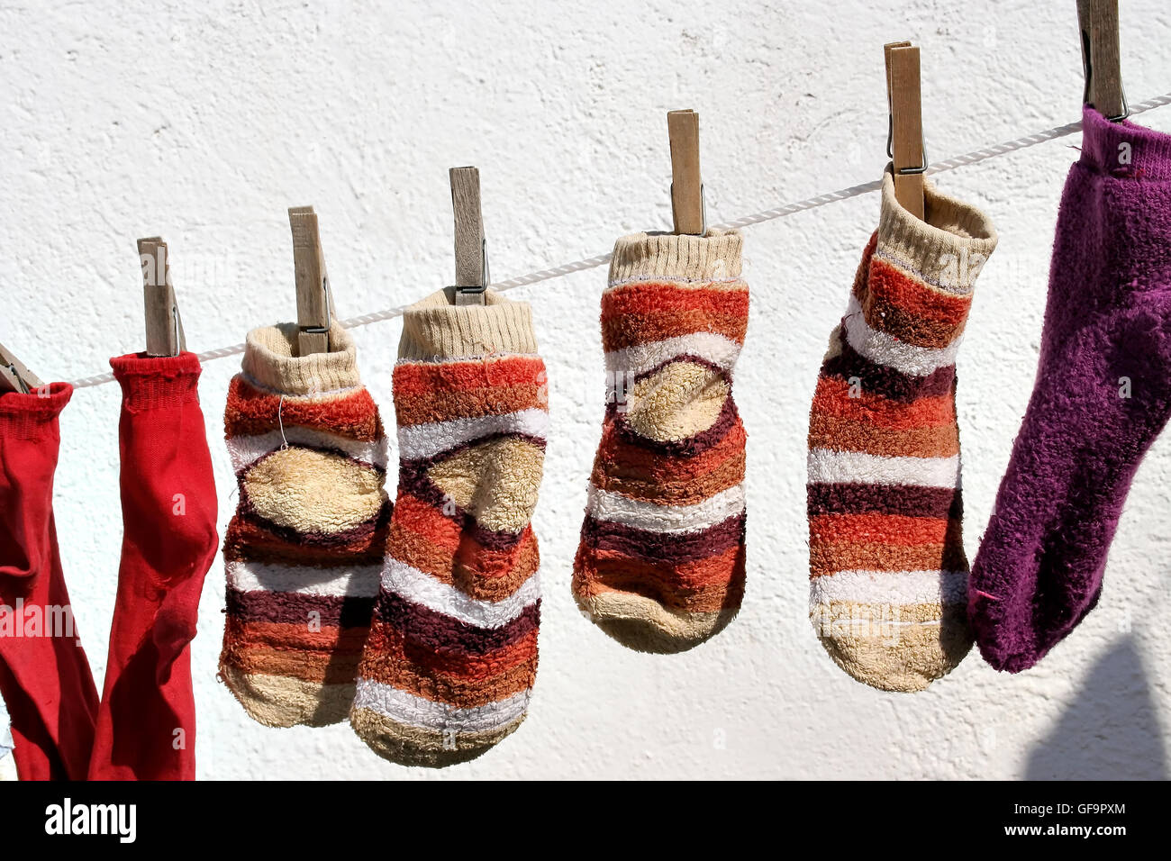 Socks hanging from a rope with white wall. Horizontal image. Stock Photo