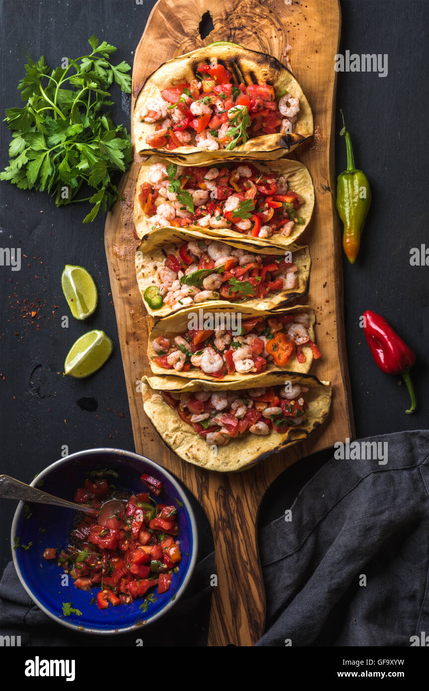 Shrimp tacos with homemade salsa, limes and parsley Stock Photo