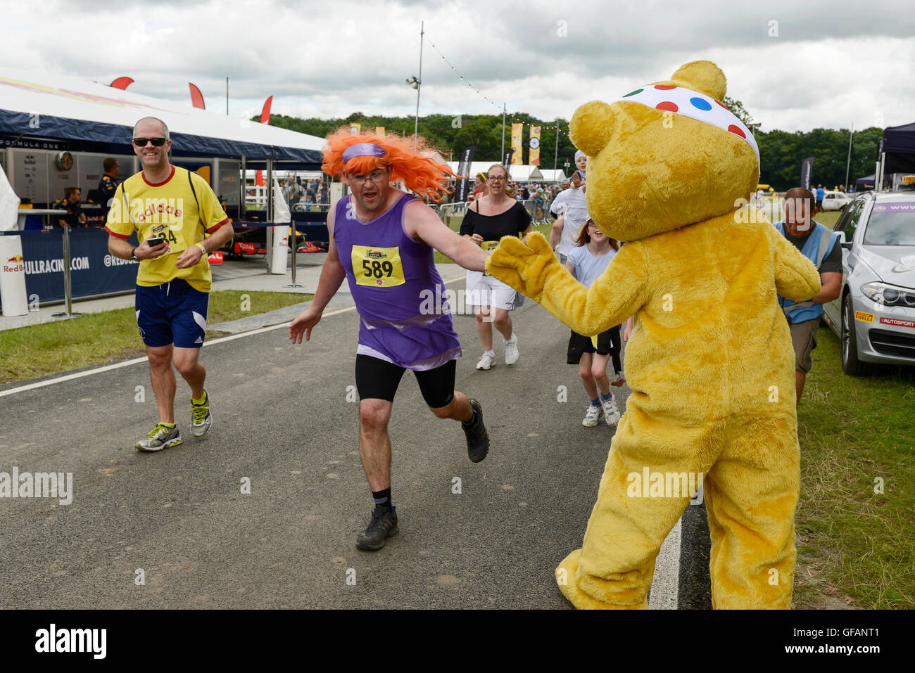 Carfest North, Bolesworth, Cheshire, UK. 30th July 2016. Pusey giving high fives to competitors as they reach the finish line of the Great Festival Dash fun run in aid of Children In Need. The event is the brainchild of Chris Evans and features 3 days of cars, music and entertainment with profits being donated to the charity Children in Need. Andrew Paterson/Alamy Live News Stock Photo