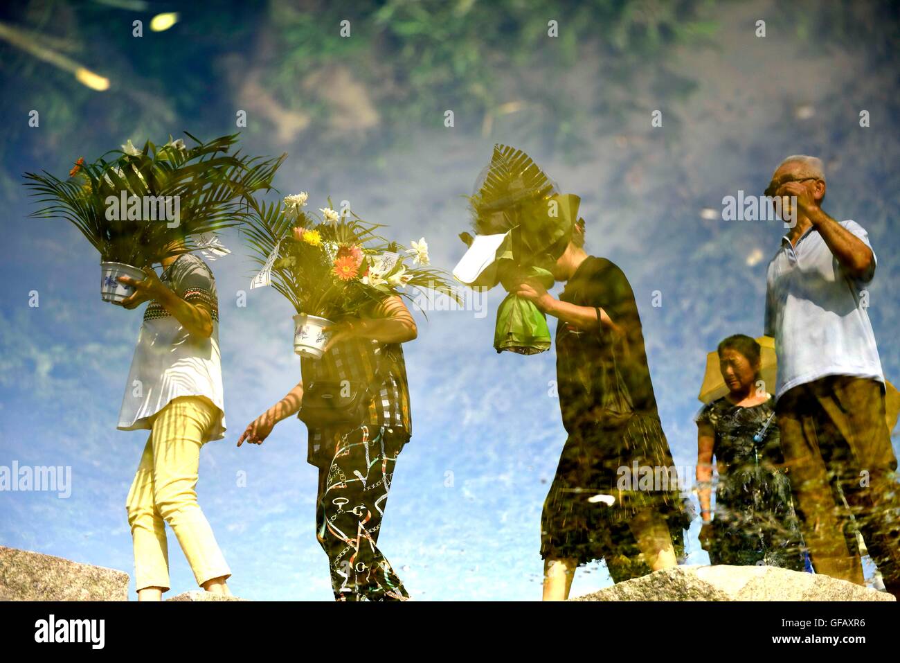 Beijing, China's Hebei Province. 28th July, 2016. Inverted reflection shows people mourning for relatives killed in the 1976 Tangshan earthquake in front of a memorial wall in Tangshan, north China's Hebei Province, July 28, 2016. © Wu Xiaoling/Xinhua/Alamy Live News Stock Photo