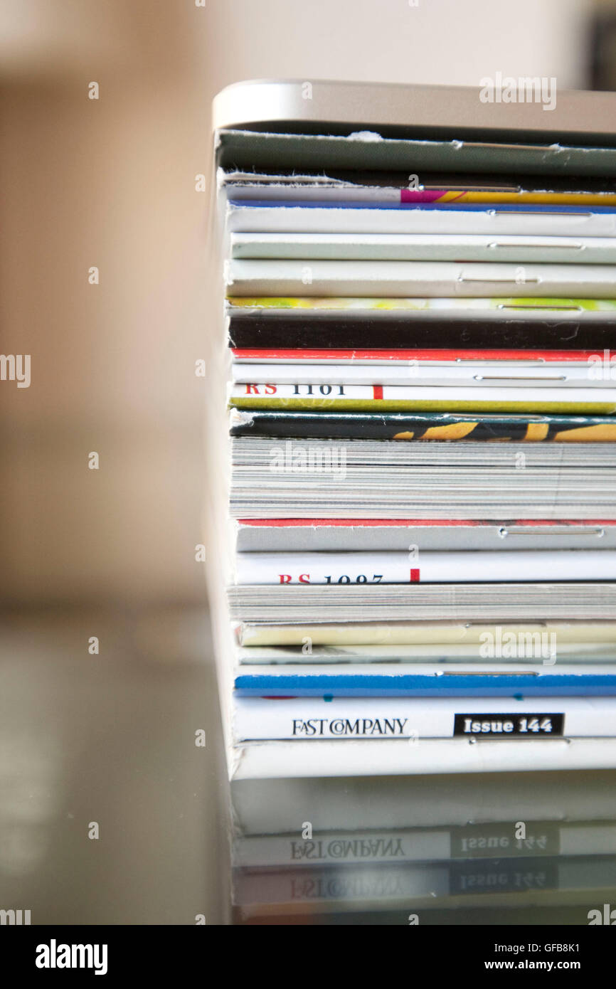 An Apple iPad device sits on a pile of print magazines on an apartment table, 2010. Stock Photo