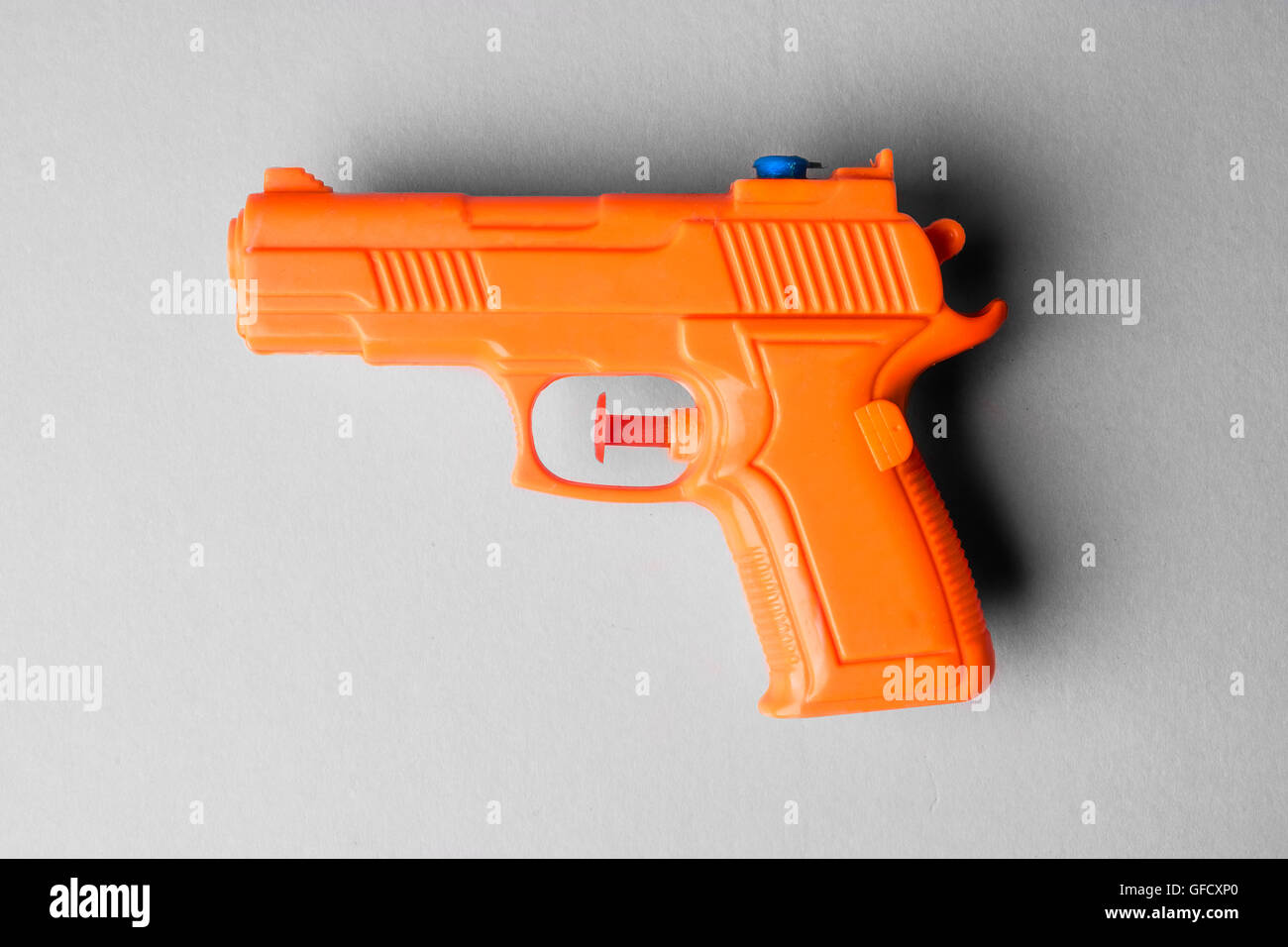 Orange plastic water pistol isolated on a white background Stock Photo