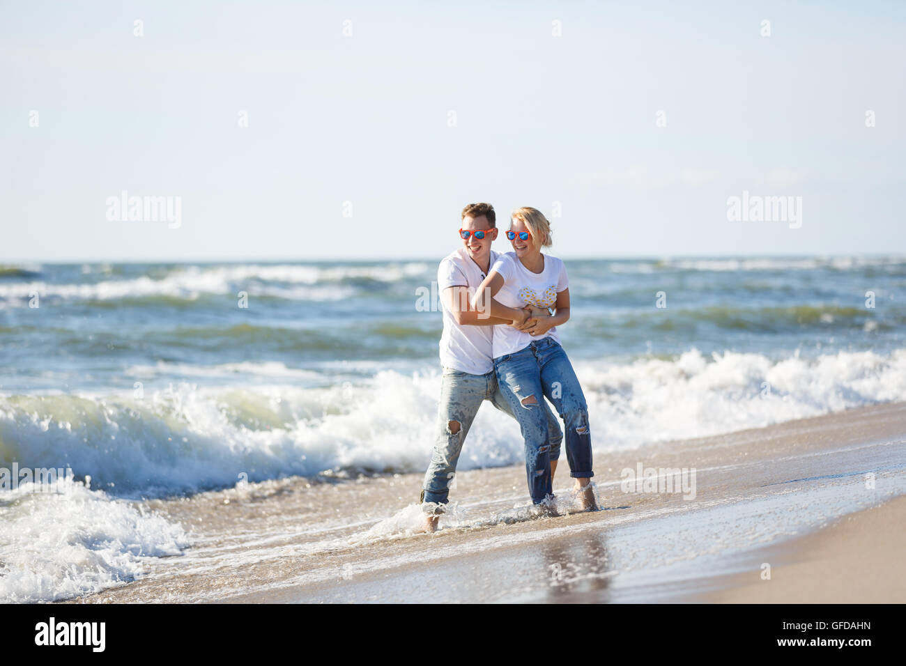 Cheerful couple are hugging on the beach, summer time Stock Photo