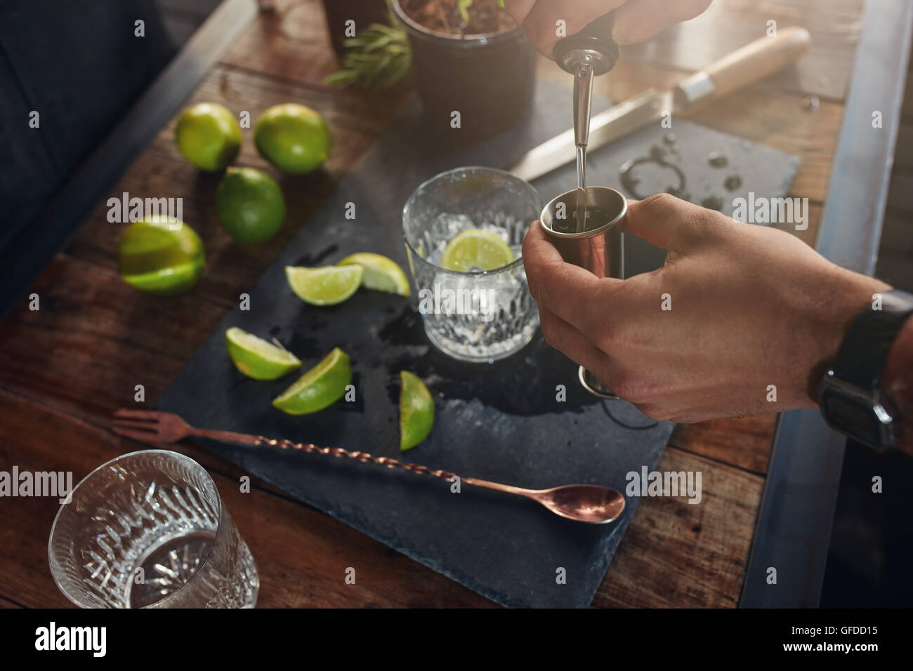 Closeup of man hands pouring alcoholic drink in to a jigger to prepare a cocktail. Barman preparing the cocktail at  the bar cou Stock Photo