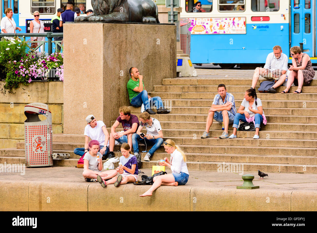 Goteborg, Sweden - July 25, 2016: Real people in everyday life. Groups of people sitting on stone stairs enjoying the day while Stock Photo