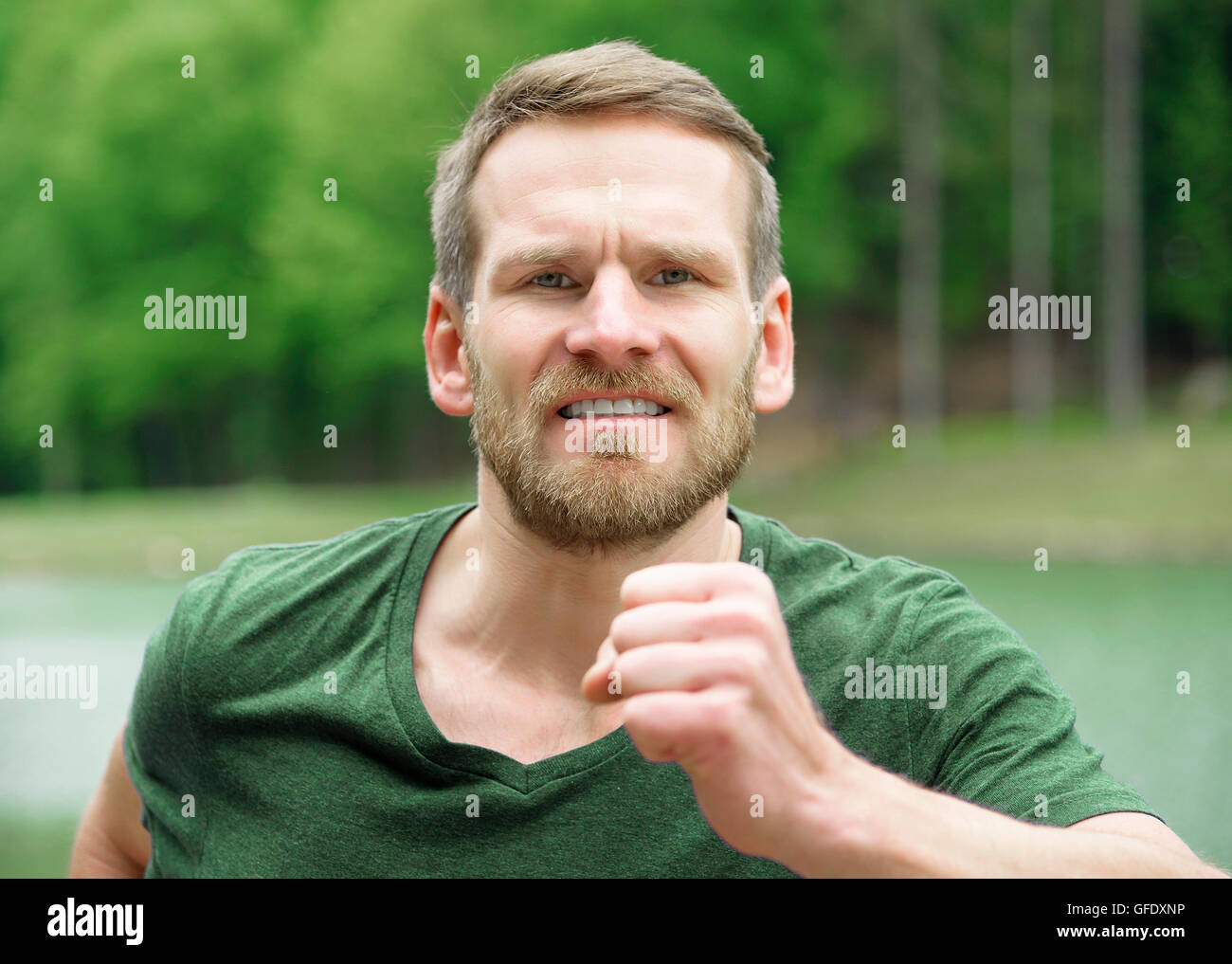 Man running outdoors closeup. Male athlete jogging outside in park ...