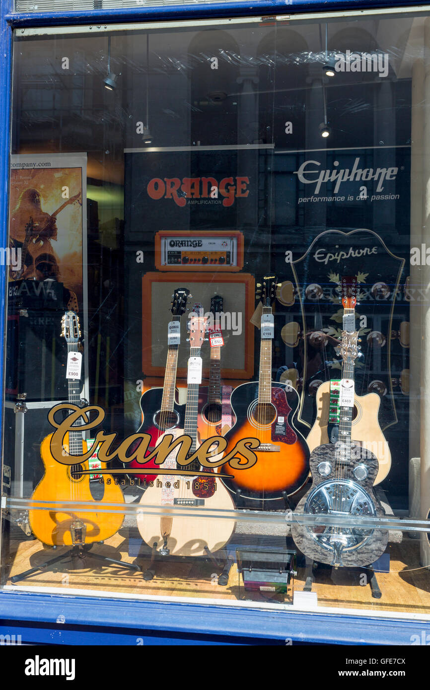 Colourful guitar display in the window of Cranes music shop, Cardiff, South Glamorgan, Wales, UK Stock Photo