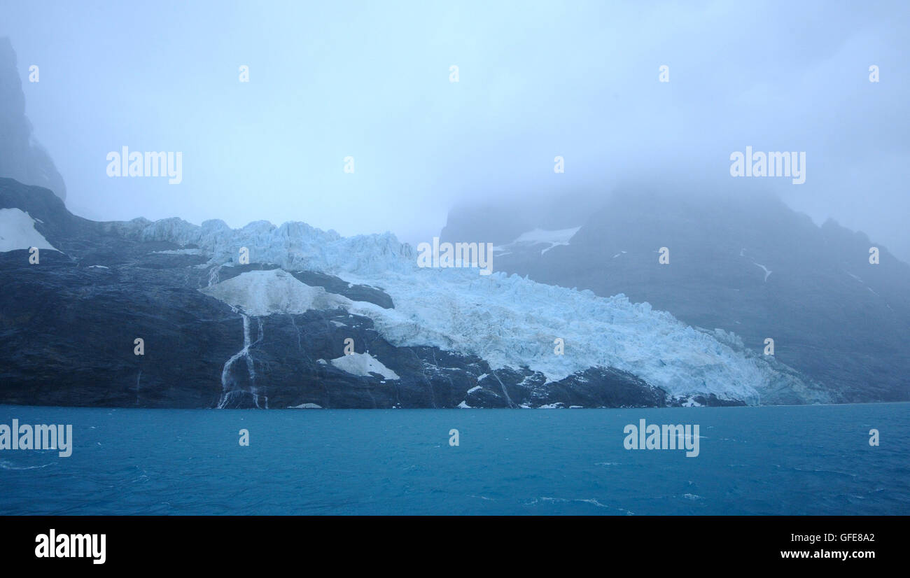 Fog shrouds glaciers flowing from the interior of South Georgia into Drygalski Fjord.  Drygalski Fjord, South Georgia. Stock Photo