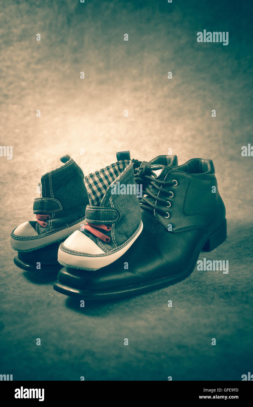 Daddy's boots and baby's sneakers, on wood background, fathers day ...