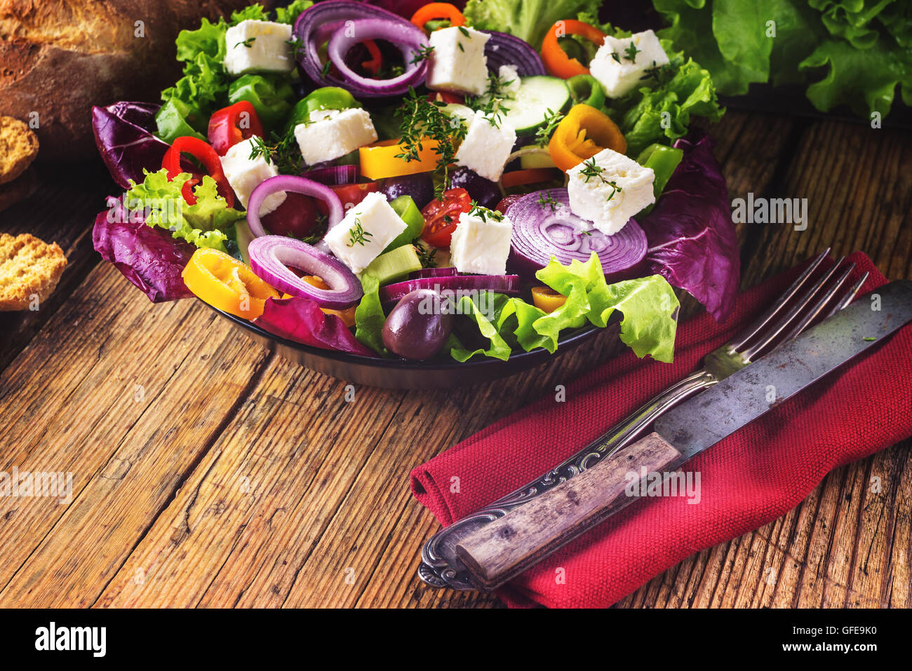 Crisp spring salad with feta cheese, full of vitamins and colors. Greec Salad on vintage table Stock Photo