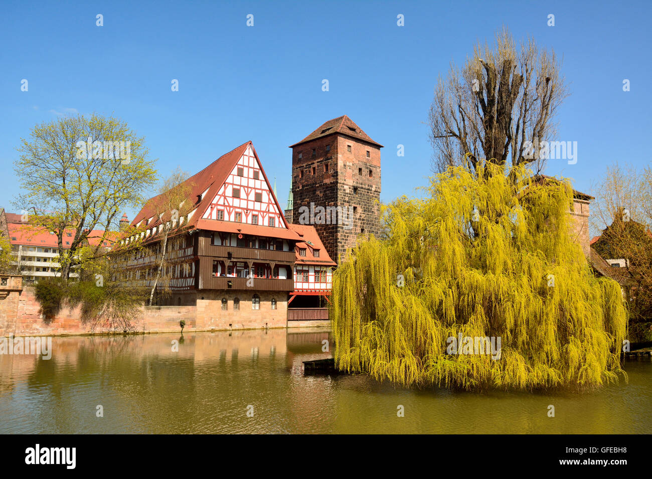 View of historic buildings on the bank of Pegnitz river and willow tree in Nuremberg old town district Stock Photo