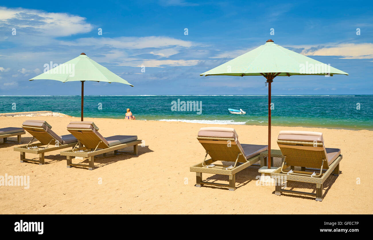 Lounge chairs with sun umbrella on the Sanur Beach, Bali, Indonesia