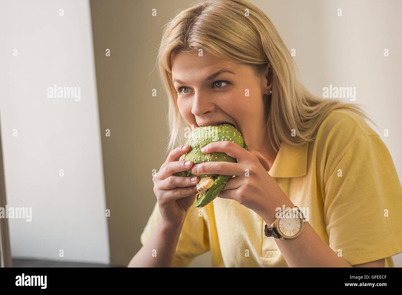 Woman eating vegan burger in restaurant Stock Photo