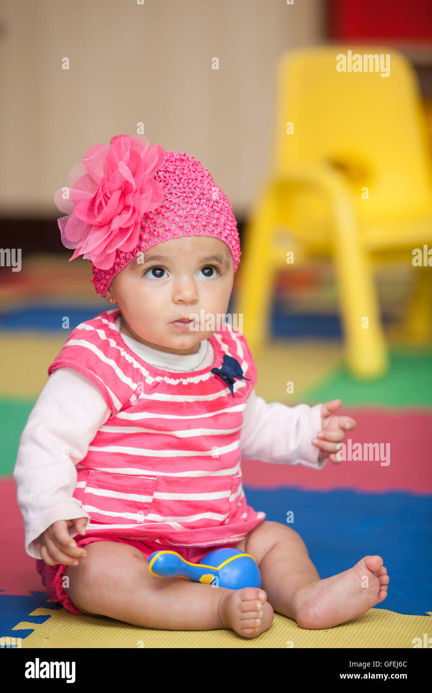 Baby girl dressed in pink with a rumba shaker Stock Photo