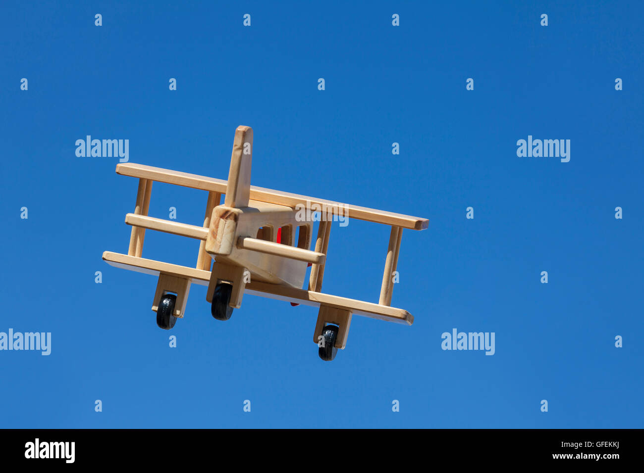Wooden Plane flying with blue sky - Going away Stock Photo