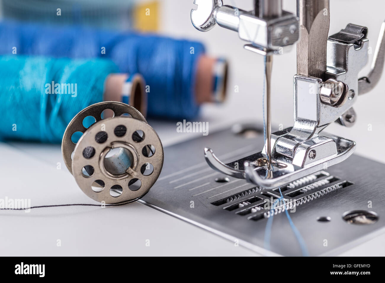 Detail of sewing machine with threads and a spool of thread Stock Photo