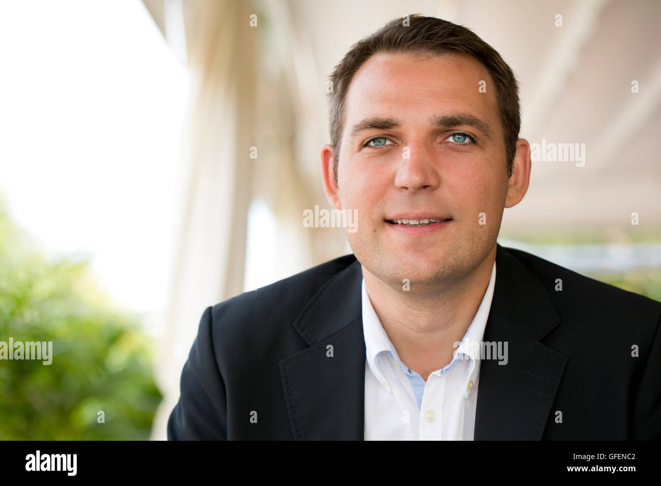 Close-up portrait of a young business man in a dark suit and white ...