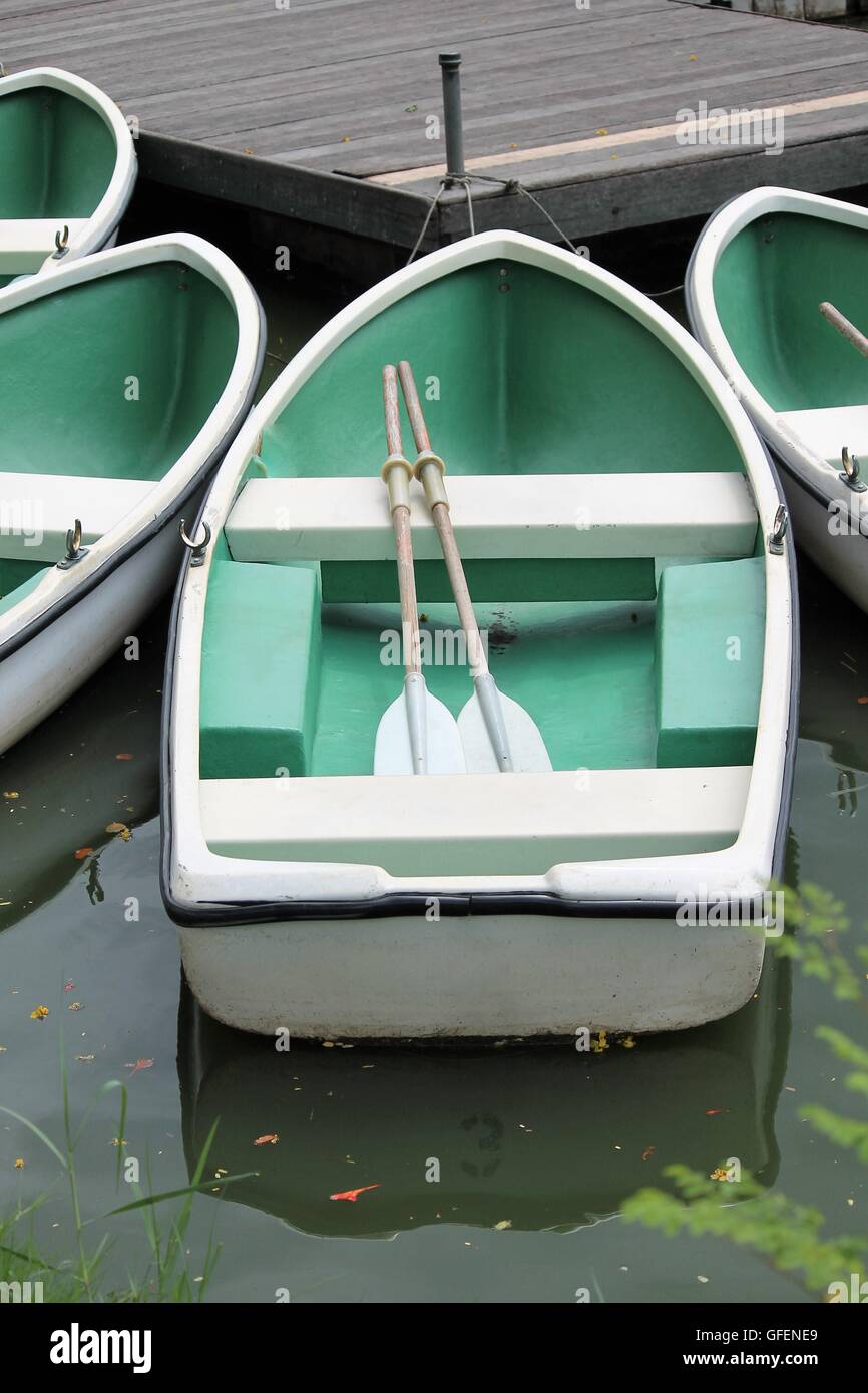 small green row boat with paddles oars and seat ready to explore ...