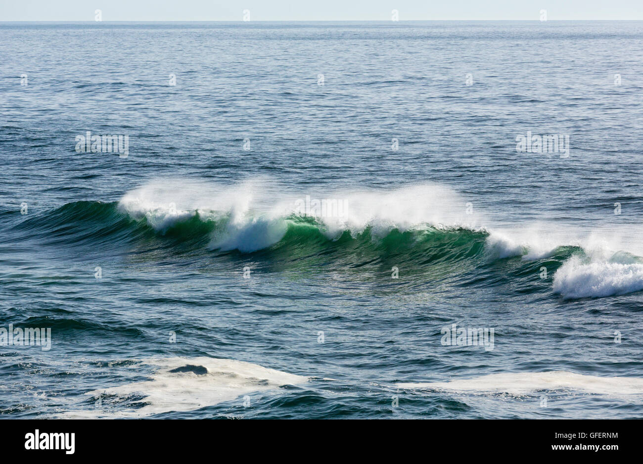 Sea surf wave with foam and splashes. View from beach. Stock Photo