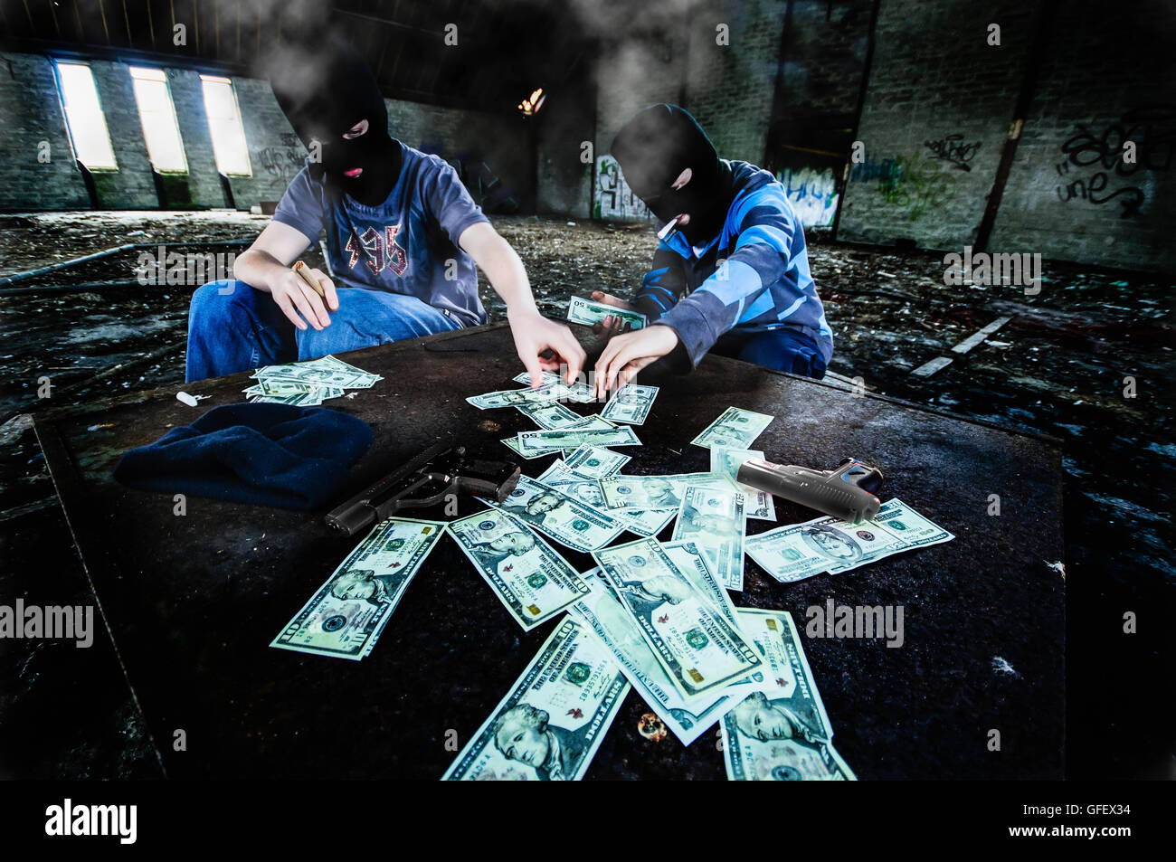 Two men wearing balaclavas count money after a robbery Stock Photo
